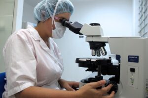 mujer mirando por el microscopio
